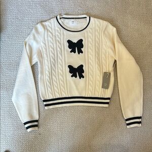Chic Cream and Black Sweater with Bow Accents